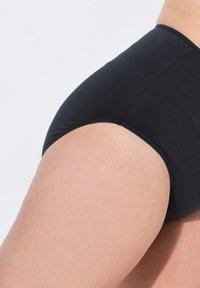 Zwarte high-waisted onderbroek, zachte stof, elastische tailleband en minimale stiksels zichtbaar langs de randen, aansluitend ontwerp.