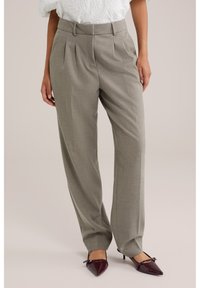 Heledatähkvalged, kohandatud püksid voldidega, kõrge vöökohaga ja laia säärega. Sobitatud burgundi punaste terava ninaga kontsakingadega, millel on vurrukujulised detailid.