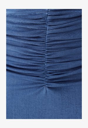 Blaue Stoff mit senkrechtem gerafftem Rüschen, die strukturierte horizontale Falten und eine zentrale Nahtdetail erzeugen.