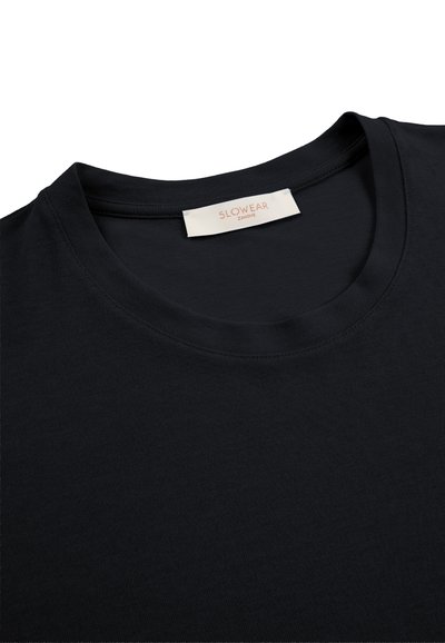 Zwart T-shirt met ronde hals en een wit label genaaid aan de binnenkant van de kraag met daarop de merknaam "SLOWEAR ZANONE".