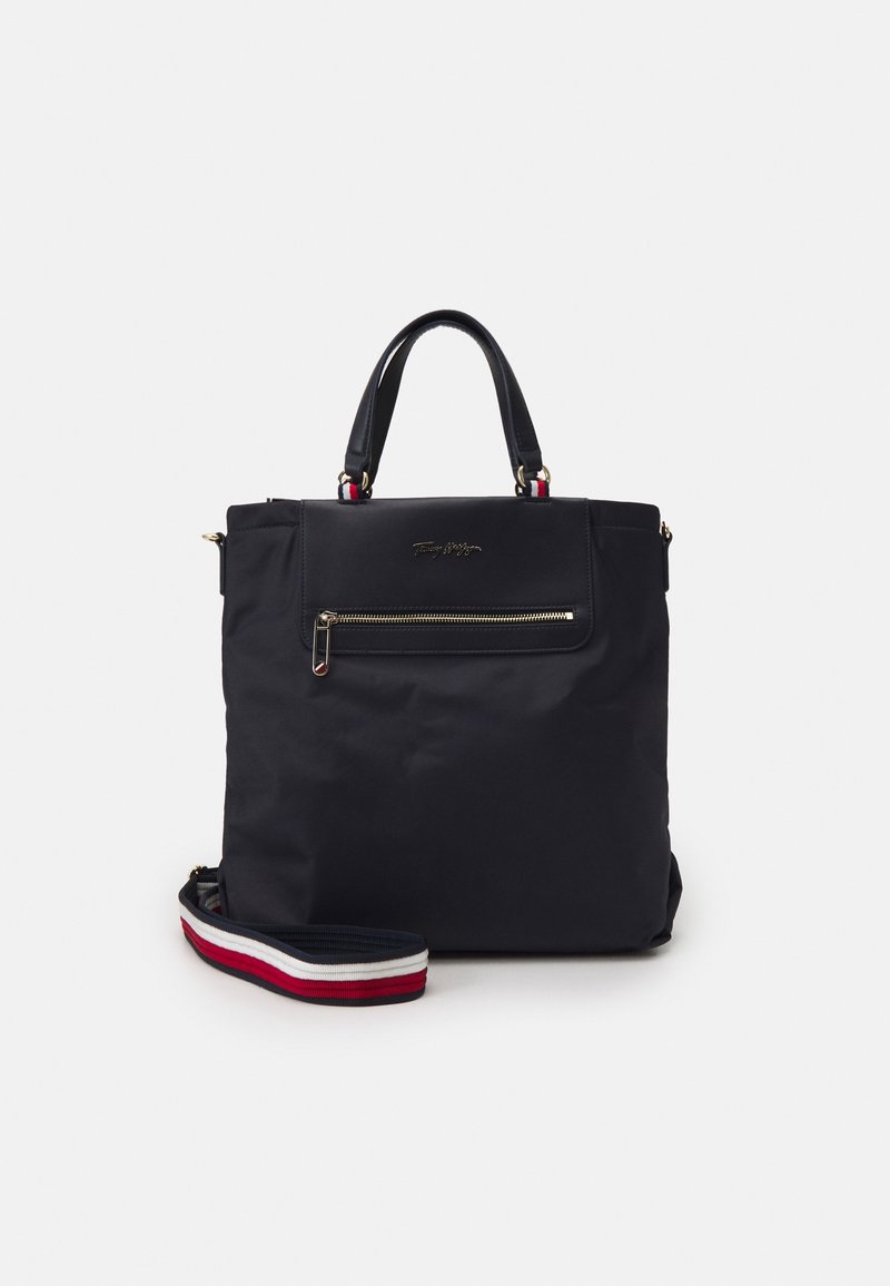 Borsa a spalla in nylon nera con hardware dorato. Presenta una tasca con zip frontale e una tracolla staccabile con righe rosse, bianche e blu.