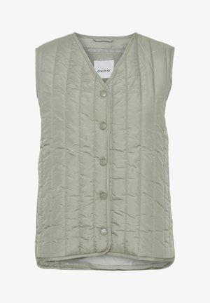 Viegli zaļa, ar polsterējumu un bez piedurknēm, ar V veida izgriezumu, sešiem pogu aizdari un gludu tekstūru ar smalkām šuvju rakstām.