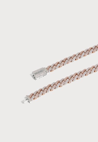 Bracelet à maillons en or rose et argent avec un fermoir boîte couvert de petites pierres scintillantes sur un fond blanc.