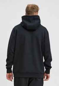 Svart huvtröja, fleece-material, enkel design, vanlig passform, ribbade �ärmslut och nederkant, utan synliga logotyper eller mönster.