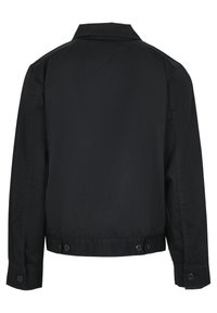 Must must vest, mille häälde, pikad varrukad ja nuppudega kinnitused mansettidel ja alumisel äärel. Valmistatud siledast kangast, lihtne disain.