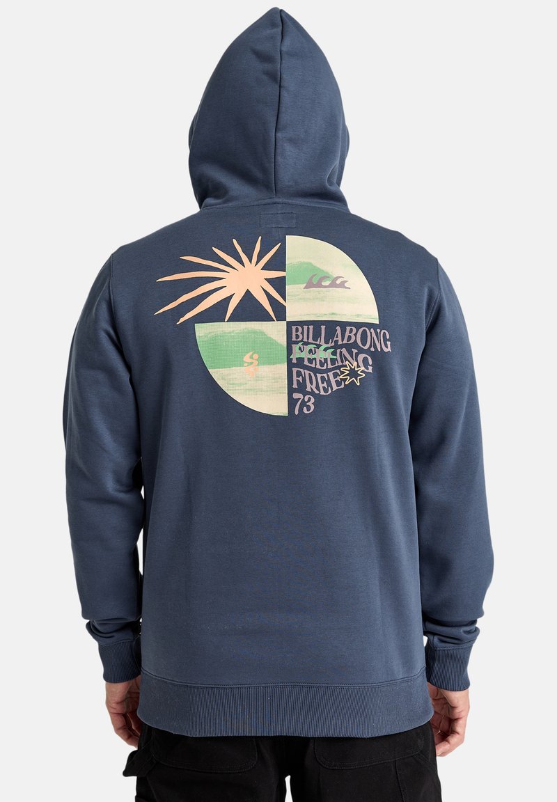 Donkerblauwe hoodie gemaakt van zacht materiaal, met een grote grafische afbeelding op de achterkant met een zon, golven en de tekst "BILLABONG FEELING FREE 73."