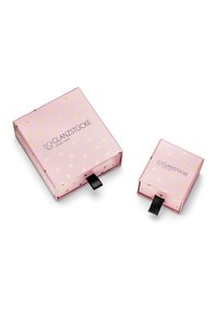 Rozā dāvanas kastītes ar zelta sirds rakstiem. Lielākajai kastītei ir melns vilkšanas cilpa; abas kastītes ir ar zīmola nosaukumu "GLANZSTÜCKE MÜNCHEN."