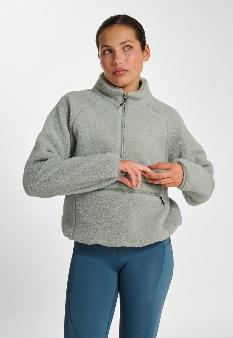 Fleece pullover in zacht mintgroen, voorzien van een hoge kraag, halve rits en een zak met rits. Gestructureerde, gezellige stof met raglanmouwen.