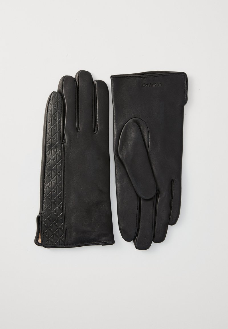 Luvas de couro pretas com um acabamento suave de um lado e um padrão de diamante texturizado do outro, com um ajuste justo e sem hardware visível.