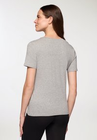 Szara koszulka z krótkim rękawem wykonana z miękkiej mieszanki bawełny, z klasycznym okrągłym dekoltem i luźnym krojem. Materiał ma gładką teksturę z minimalną ilością szwów.