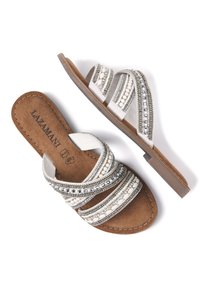 Platenspannende sandalen met meerlagige bewerkte banden in zilver, wit en zwart. Bruine gevoerde binnenzool en gestructureerde zijdetails.