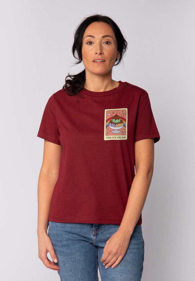 Burgunderfarbendes Baumwoll-T-Shirt mit einer bunten Eistrockengrafik und dem Text "DAS EIS" sowie Sternelementen auf der Vorderseite.