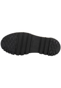 Suela de zapato de goma negra con un patrón de agarre texturizado, que presenta ribetes y surcos prominentes para mayor tracción. Marcada con el logo y tamaño 38.