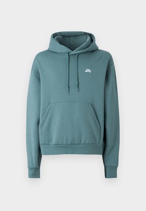 Sudadera con capucha Nike SB en color verde azulado, con bolsillo frontal tipo canguro, capucha con cordón ajustable y pequeño logo blanco en el pecho izquierdo, presentada sobre un fondo blanco.