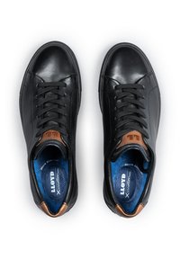 Sneakers neri in pelle con una texture liscia, caratterizzati da un accento marrone vicino al tallone e un interno imbottito blu. Design con lacci.