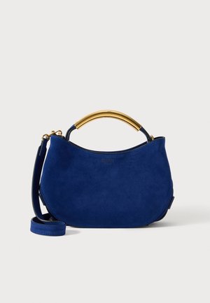 Sac à épaule en daim bleu avec une poignée en métal doré incurvée et une bandoulière amovible, présentant un fond arrondi et un logo subtil à l'avant.