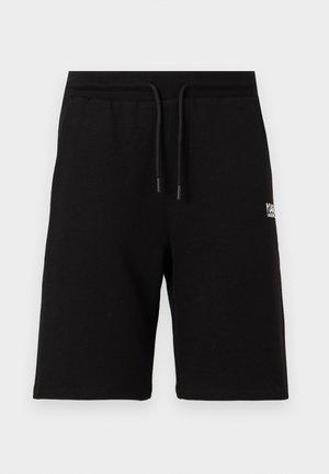 Shorts noirs mi-cuisses avec ceinture élastique et cordon de serrage, arborant un petit logo blanc sur la cuisse droite.