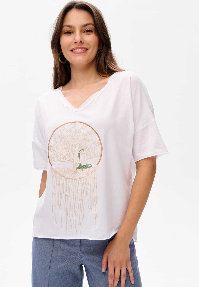 Weißes V-Ausschnitt-T-Shirt aus weichem Stoff, mit einem runden, goldenen Stickdesign eines Baumes mit hängenden Akzenten.