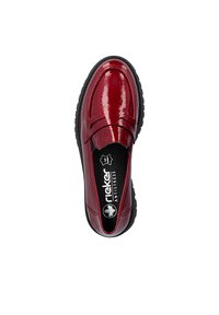 Mocassin en cuir rouge brillant avec semelle noire, bout arrondi, et marquage "rieker Antistress" à l'intérieur sur la semelle intérieure.