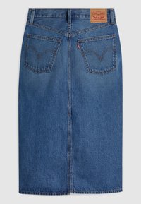 Jupe en denim bleu avec poches arrière, couture centrale, passants pour ceinture, étiquette rouge Levi's sur la poche droite et patch en cuir Levi Strauss & Co. sur la ceinture.