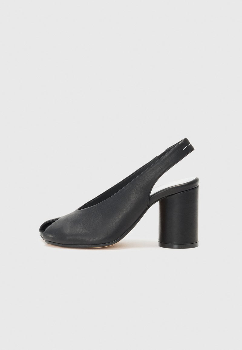 Μαύρες δερμάτινες σάπιες με ανοιχτό μπροστινό μέρος, με στρογγυλό τετράγωνο τακούνι και λεία υφή. Απλός σχεδιασμός με ελάχιστες λεπτομέρειες.