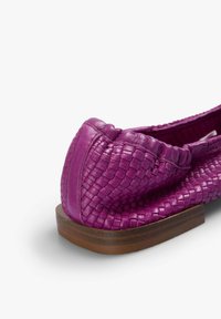 Zapato plano de cuero trenzado morado con parte superior texturizada, puntera redondeada y suela de madera con un ligero tacón.