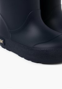Stivali di gomma blu con una suola nera testurizzata, caratterizzati da un design liscio e curvo e un logo sul lato.