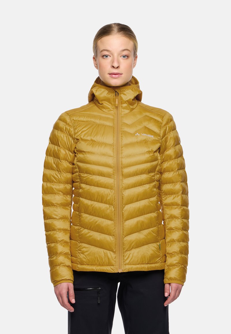 Gelbe isolierte Jacke mit Chevron-Steppdesign, Reißverschluss vorne, hohem Kragen und Logodetail auf der Brust. Glatte Textur, leichtes Material.