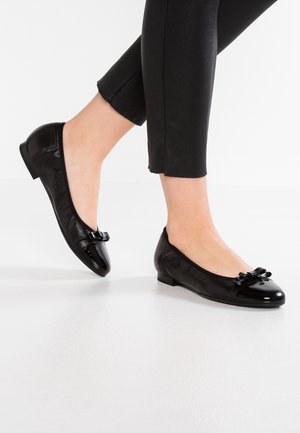 Sorte læder balletflade med en blank tæer og sløjfe accenter fortil, der har en lav hæl og en glat tekstur.