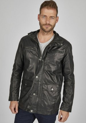 Chaqueta de cuero negra con frente con cremallera, múltiples bolsillos y detalles a presión. Cuenta con un cuello y un acabado ligeramente texturizado.