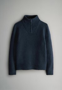 Tamsiai mėlynas megztinis su aukštu apykakle ir pusiau užtrauktuku, pagamintas iš tekstūruotos medžiagos. Ilgos rankovės, laisvas siluetas ir vientisa spalva.