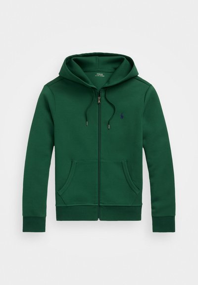 Casaco de capuz verde com fecho éclair e acabamento texturizado, apresentando um bolso tipo canguru, cordão ajustável e um pequeno logótipo no peito.