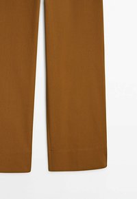 Pantalon marron avec une texture lisse et une coupe fuselée. L'ourlet est proprement fini, présentant un design classique sans éléments visibles ni accents.