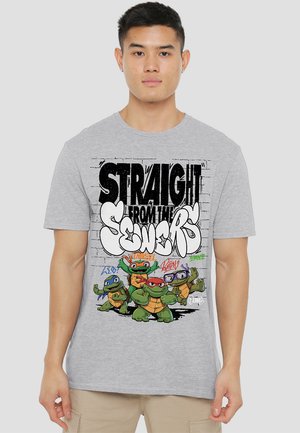 Graues Baumwoll-T-Shirt mit einem grafischen Druck von vier Comic-Schildkröten und dem Text "GERADE AUS DEN KANÄLEN" im Stil von Schwarz-Weiß-Graffiti.