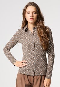 Brown gedessineerde overhemd met lange mouwen en knoopsluiting, voorzien van een geometrisch patroon en blauwe accenten, gemaakt van zachte stof.