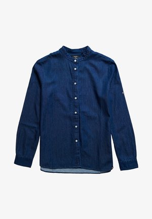 Camisa vaquera azul oscuro de manga larga con cuello mao y botones blancos en la parte delantera, extendida sobre un fondo blanco.