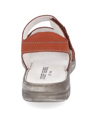 Sandaia de cuero marrón con dos correas anchas y una plantilla texturizada y acolchada. Presenta una suela gris, ligeramente elevada, con costuras visibles.