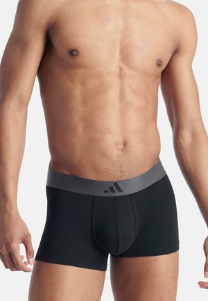 Schwarze Baumwoll-Boxerbriefs mit einem grauen elastischen Bund, der drei schwarze Streifen aufweist. Der Stoff ist glatt und hat eine enganliegende Passform.