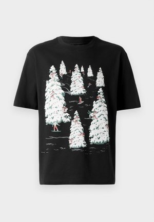 T-shirt noir avec un graphisme d'arbres recouverts de neige blanche et de skieurs colorés parmi eux. Matière en coton, col rond, manches courtes.