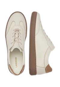 Kremowe skórzane sneakersy z teksturowanym wykończeniem, przedstawiające brązowe gumowe podeszwy i zapięcie na sznurówki. Akcenty obejmują brązowy obcas i różowe sznurówki.