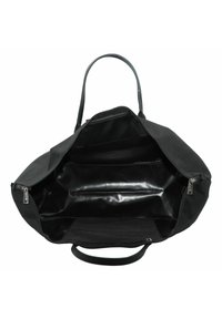 Sac fourre-tout noir avec un extérieur texturé, il dispose d'un intérieur spacieux, de compartiments zippés et de deux poignées robustes pour le transport.