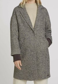 Cappotto in misto lana a motivo pied de poule con colletto a punta, tasche laterali e accenti scuri a contrasto sulle maniche, in tonalità di grigio e beige.