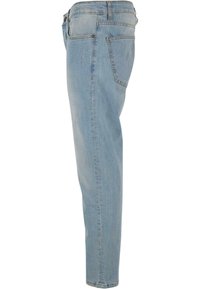 Vaaleansiniset farkut suoran lahkeen muotoilulla, joissa on hienovaraisia kulutustyylejä ja tavalliset taskujen paikat.