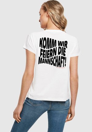 Balta medvilninė marškinė su trumpomis rankovėmis, ant nugaros esantis ryškus juodas tekstas: "KOMM WIR FEIERN DIE MANNSCHAFT!" galimi įvairių dydžių.