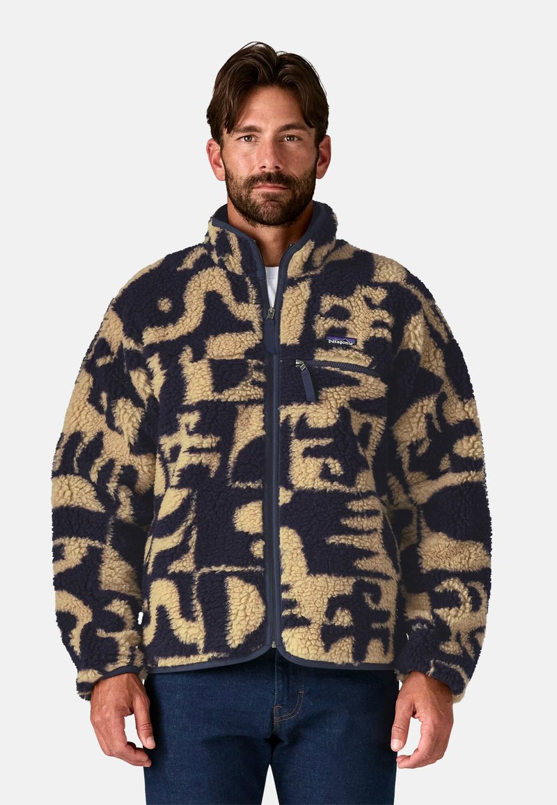 Giacca in fleece con zip frontale, caratterizzata da un motivo astratto blu navy e beige. Ha un colletto alto e una tasca sul petto con zip.