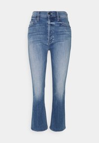 Jeans de mezclilla azul acampanados con cintura alta, que cuentan con un cierre de botón, diseño de cinco bolsillos y un acabado deslavado en las piernas inferiores.