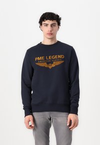 Marineblauwe sweatshirt met geborduurde "PME LEGEND" en vleugels in goud. Klassieke ronde hals, geribde manchetten en zoom, gemaakt van zachte stof.