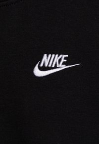 Fekete pulóver anyag fehér hímzett Nike logóval. A design sima textúrával és szabványos kerek nyakkal rendelkezik.