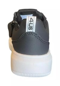 Sneaker nera con tomaia testurizzata, suola bianca e un evidente lacciolo sul tallone contrassegnato "4US". Tra le caratteristiche ci sono cuciture a contrasto e un design che garantisce una vestibilità sicura.