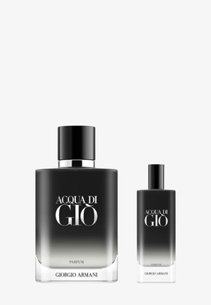 Due bottiglie di profumo in vetro, una grande e una piccola. Entrambe presentano un design a gradiente dal nero al grigio con etichette e tappi argentati.